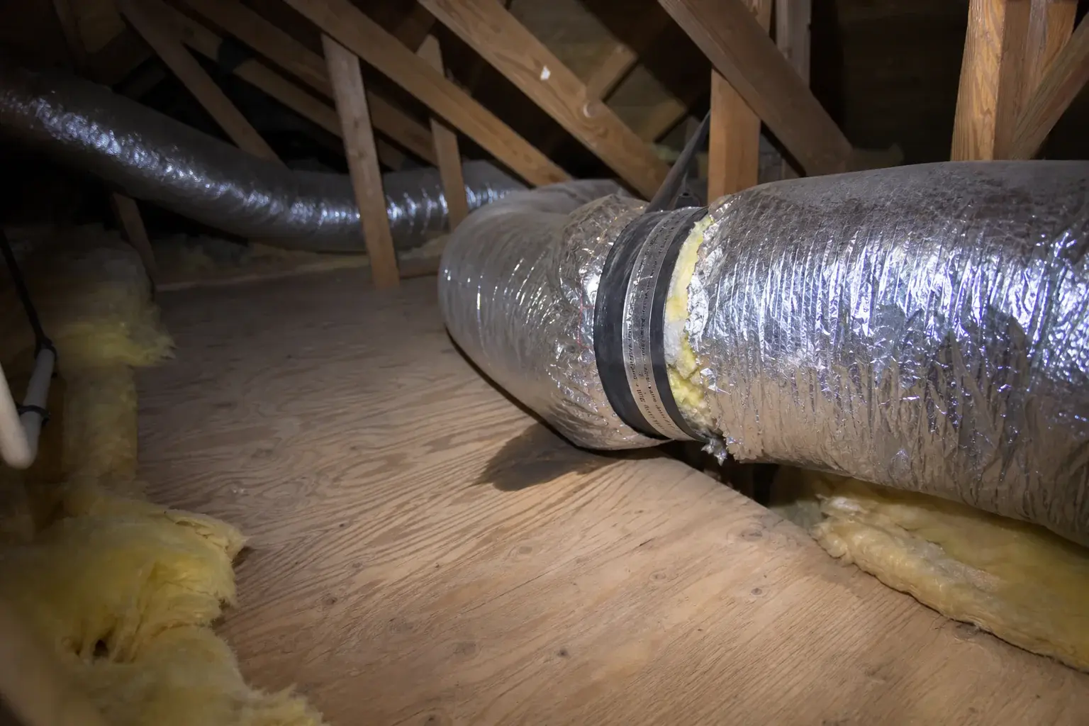 Separated flex duct joint leaking cooled air inside a residential attic